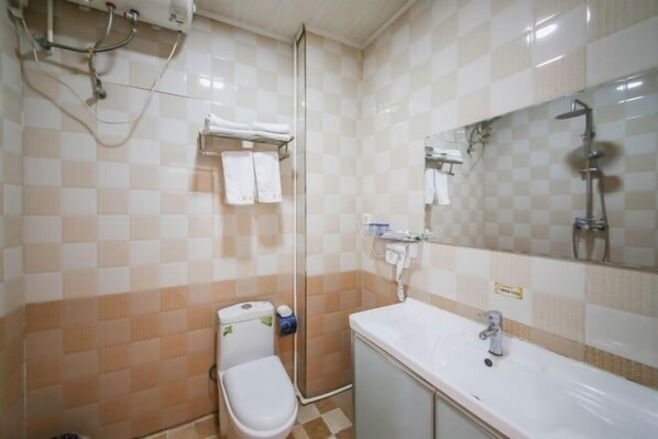 Un baño con inodoro, lavamanos y ducha.