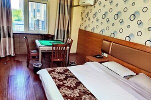 Una habitación de hotel con una cama, un escritorio con una mesa verde y una pared con un diseño.