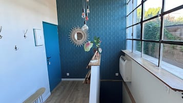 Een moderne keuken met een inbouwoven, een raam met uitzicht op groen en een decoratieve lamp.
