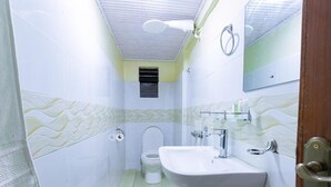 A small bathroom with a toilet, sink, and mirror. - Markson Hotel Kilimani (Nairobi)