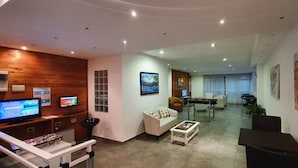 Ein modernes Wohnzimmer mit einer Holz-Akzentwand, einer Couch, einem Couchtisch und einem Fernseher.