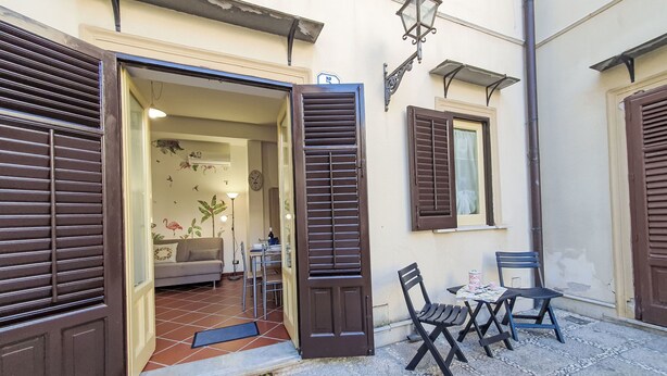An open doorway leading to a living room with a sofa and a dining table.