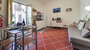 A compact living space with a dining area, kitchenette, and seating area.
