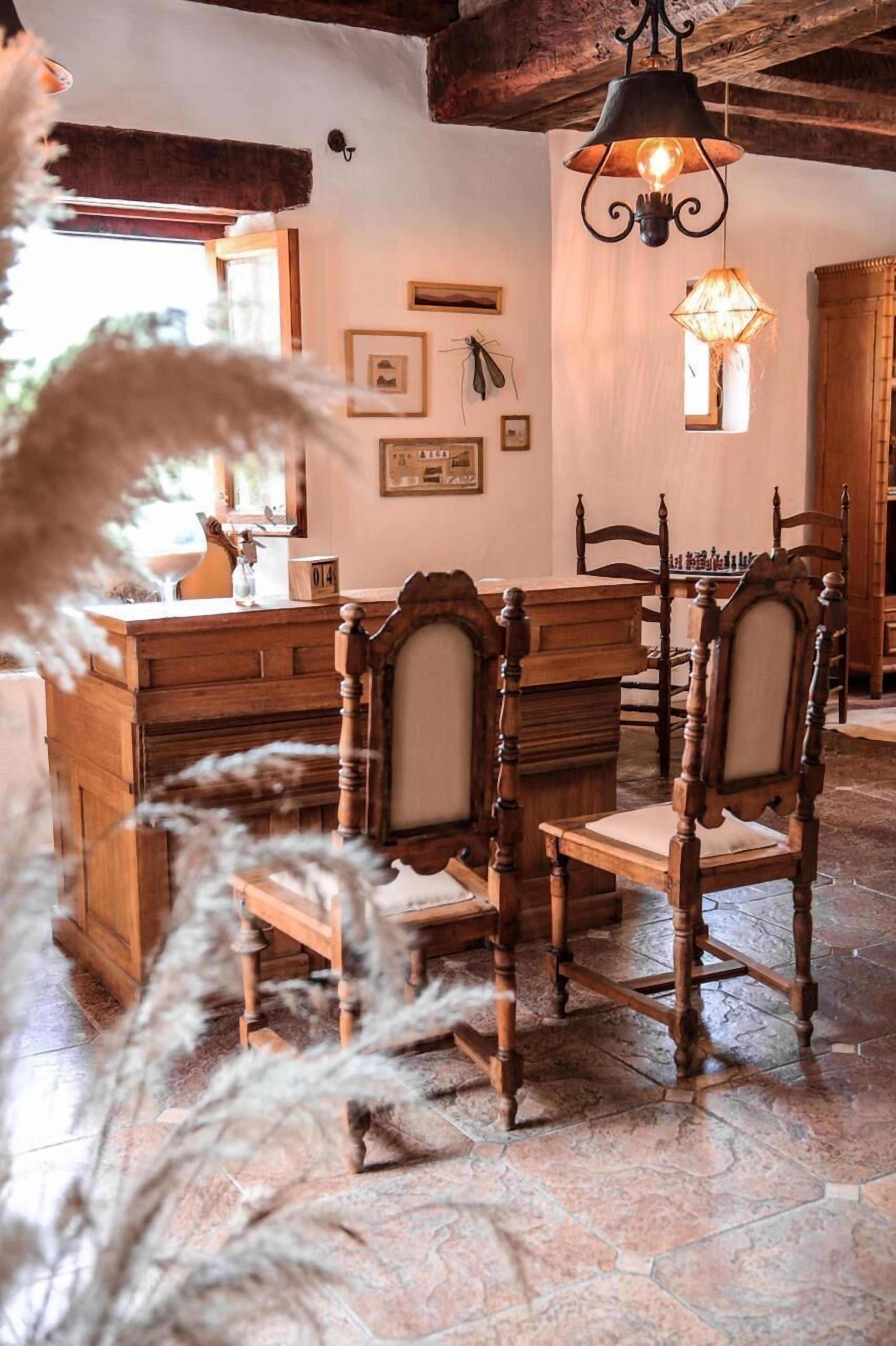 A rustic dining area with wooden furniture and a stone floor.