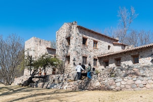 Um edifício de pedra com fachada rústica, apresentando uma parede de pedra e telhado de telhas.
