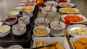 A buffet with various food items and utensils. - Blu Terrace Hotel (Blumenau)