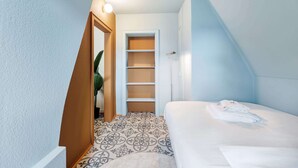 Une chambre à coucher avec un lit, une armoire, une porte et un sol à motifs.