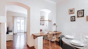 Un comedor moderno con una mesa de madera, sillas transparentes y un armario blanco.