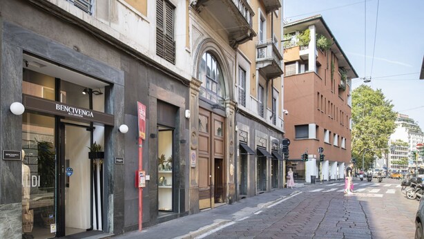 Vista de la calle con un edificio que tiene una tienda llamada 'Bencivenga' en la planta baja.
