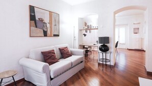 Un salón moderno con un sofá blanco, una mesa de centro y un cuadro en la pared.