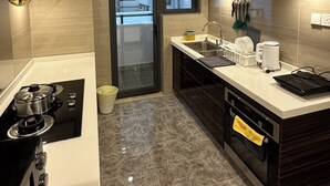 A modern kitchen with a gas stove, a sink, and a coffee maker. - R&F Seine Region (Johor Bahru)