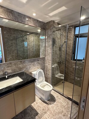 Une salle de bain moderne avec une douche en verre, un grand miroir et un sol carrelé en marbre.