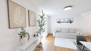Una sala de estar moderna con un sofá, una mesa de comedor y una planta en maceta.