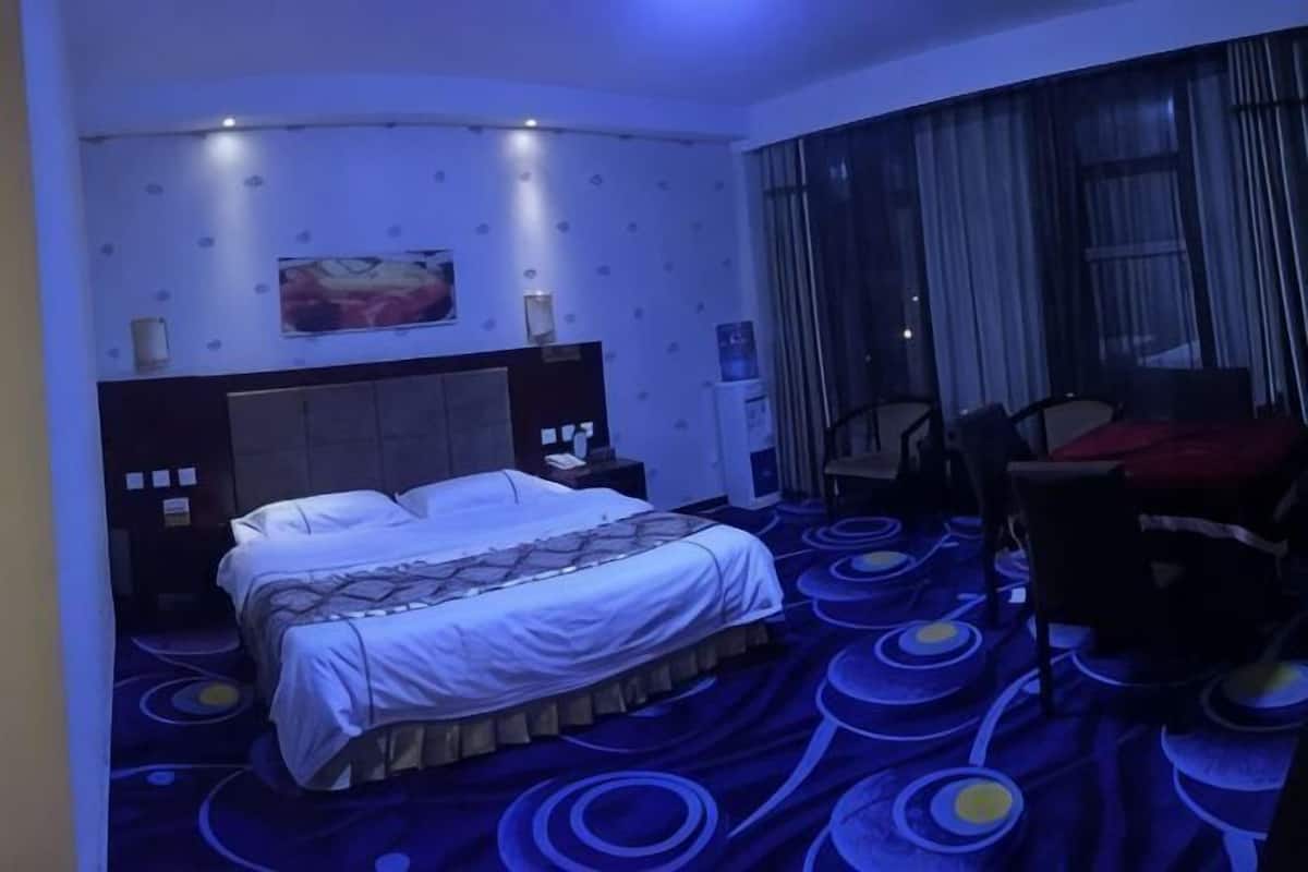 Una habitación de hotel con una cama, una mesita de noche, un escritorio y una silla.