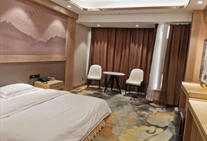 A hotel room with a bed, two chairs, a small table, a painting on the wall, and a window with curtains. - Jinhai Hyatt Hotel Linyi (Linzhang)