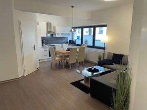Cozy living space with a dining area, sofa, and kitchen in the background.