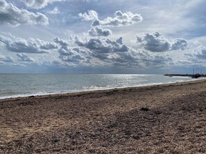 A beach with pebbles, a pier, and a cloudy sky. - GC132 - Discover Your Perfect Seaside Escape in Clacton-on-Sea! (Saint Osyth)