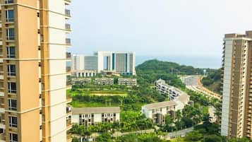 A high-rise building with multiple floors, surrounded by greenery and other buildings.