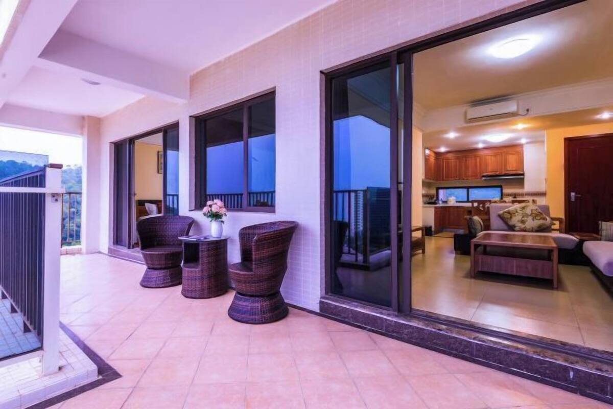 Un espacio moderno para relajarse con balcón, muebles de mimbre y vista a la cocina.