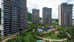 A high-rise residential building complex with multiple floors, a central courtyard with a swimming pool, and surrounding greenery. - Weifudun Holiday Apartment (Hailing Island Poly Silver Beach) (Yangjiang)