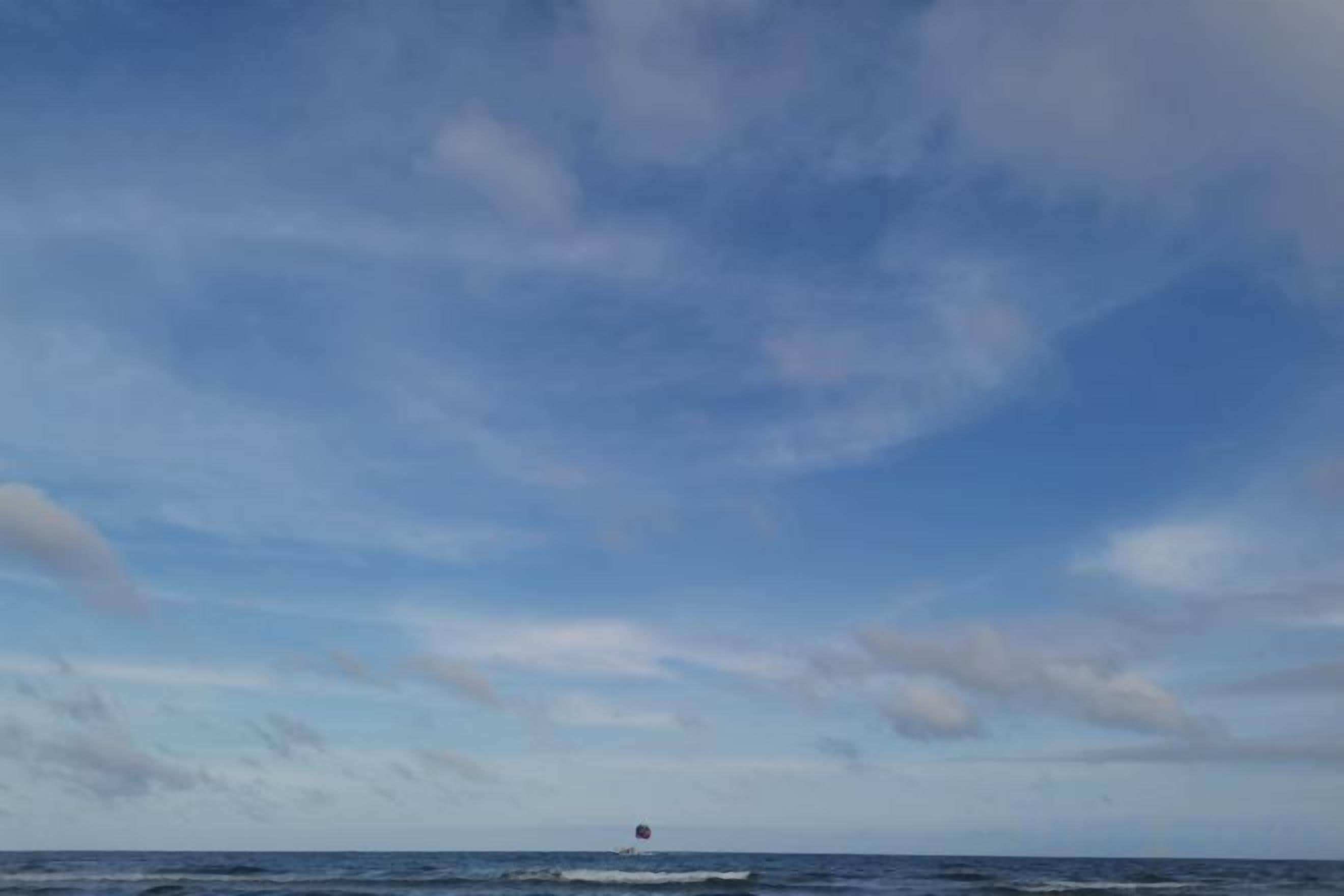 A clear sky over a body of water with a distant buoy.