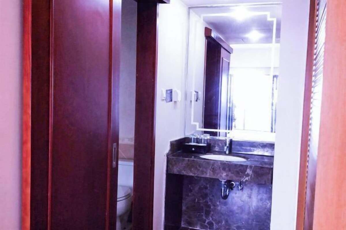 Une salle de bain avec un lavabo en marbre, un miroir et une porte en bois.