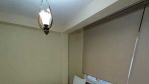 A bedroom with a large bed, a window with blinds, and a hanging light fixture. - Çarşı Marin Denizer Pension (Amasra)