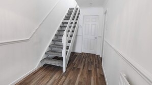 A staircase with carpeted steps leading to a white door.