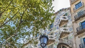 A building with unique architectural features, including balconies with organic shapes and a staircase leading to the entrance. - Habitat Apartments Barcelona Balconies (Barcelona)