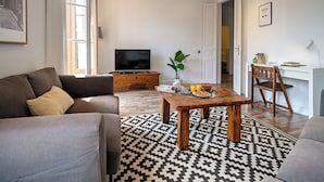 A modern living room with a sofa, coffee table, and TV. - Habitat Apartments Barcelona Balconies (Barcelona)