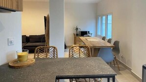 A modern living room with a dark grey table, wicker chairs, and a sofa. - La villa au palmier - 10bed, 2bath, roof terrace (Perpignan)