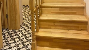 A wooden staircase with a geometric patterned floor, a brick wall, and a hanging light fixture. - HanFlats Hotel (Istanbul)