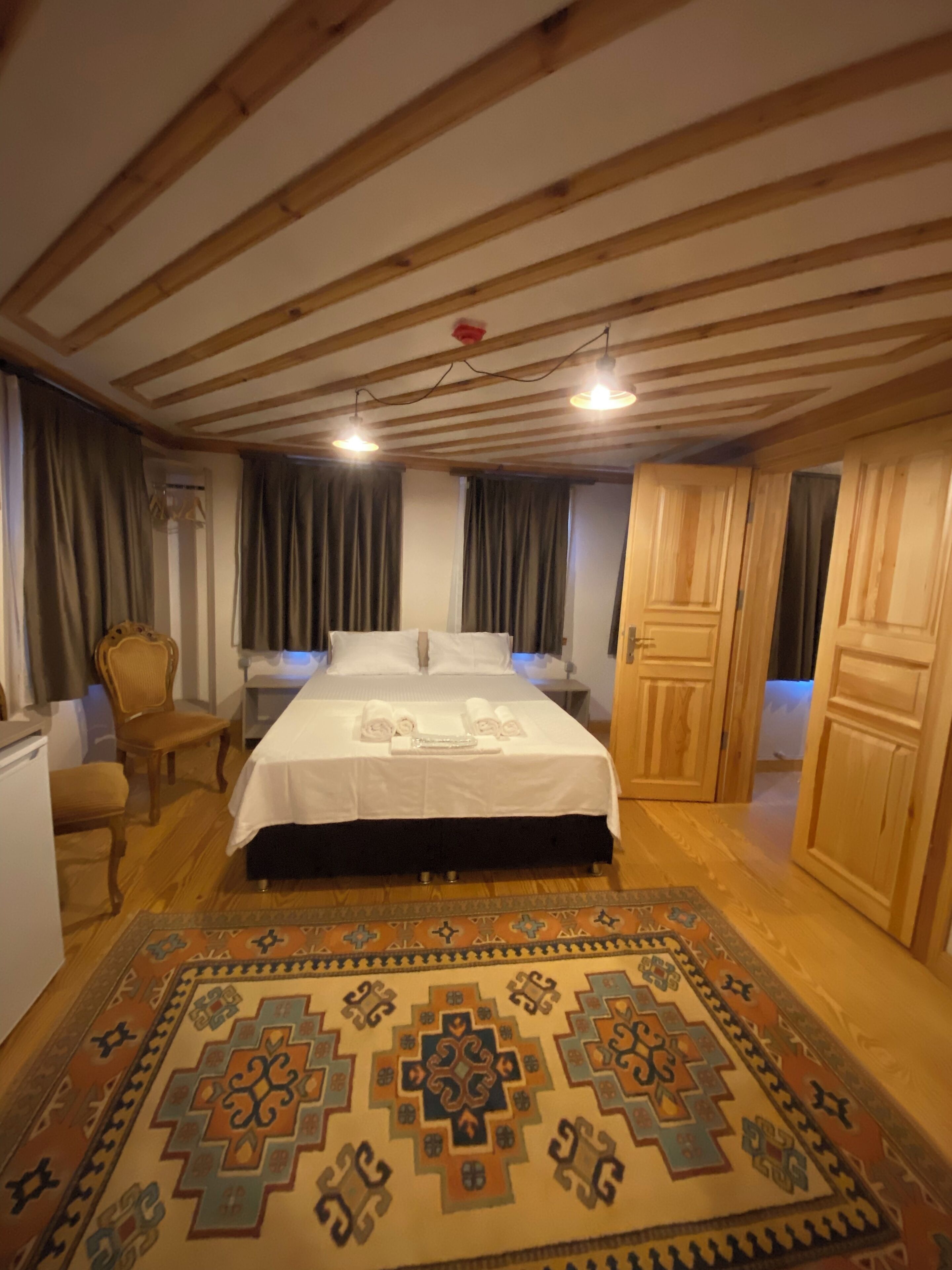 Una habitació amb un llit, una cadira, un escriptori i un armari.
