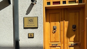 A wooden double door with a brass knocker, a nameplate reading "HAN" and "MECIDIVE HAN", and a number "6" sign. - HanFlats Hotel (Istanbul)
