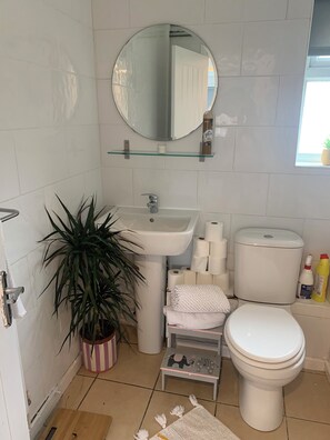 Un baño con lavamanos, inodoro y espejo.