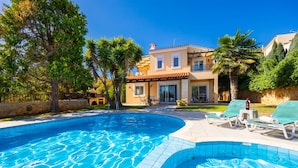 A swimming pool with lounge chairs, a house with a tiled roof, and a clear blue sky. - Villa Elessa in Rethymno (Rethymno)