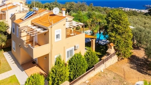 A two-story building with a balcony, a swimming pool, and a view of the sea. - Villa Elessa in Rethymno (Rethymno)