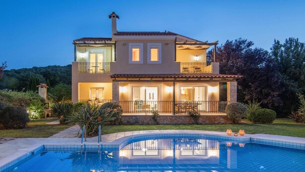 Une maison à deux étages dotée d’une piscine, d’un balcon et d’un éclairage extérieur soigné.