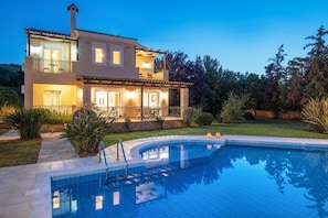 A two-story house with a swimming pool, surrounded by greenery and a well-maintained lawn. - Villa Daphni in Rethymno (Rethymno)