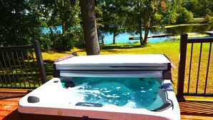 A hot tub on a wooden deck with a lake view. - Serenity On Rice Lake (Brainerd)