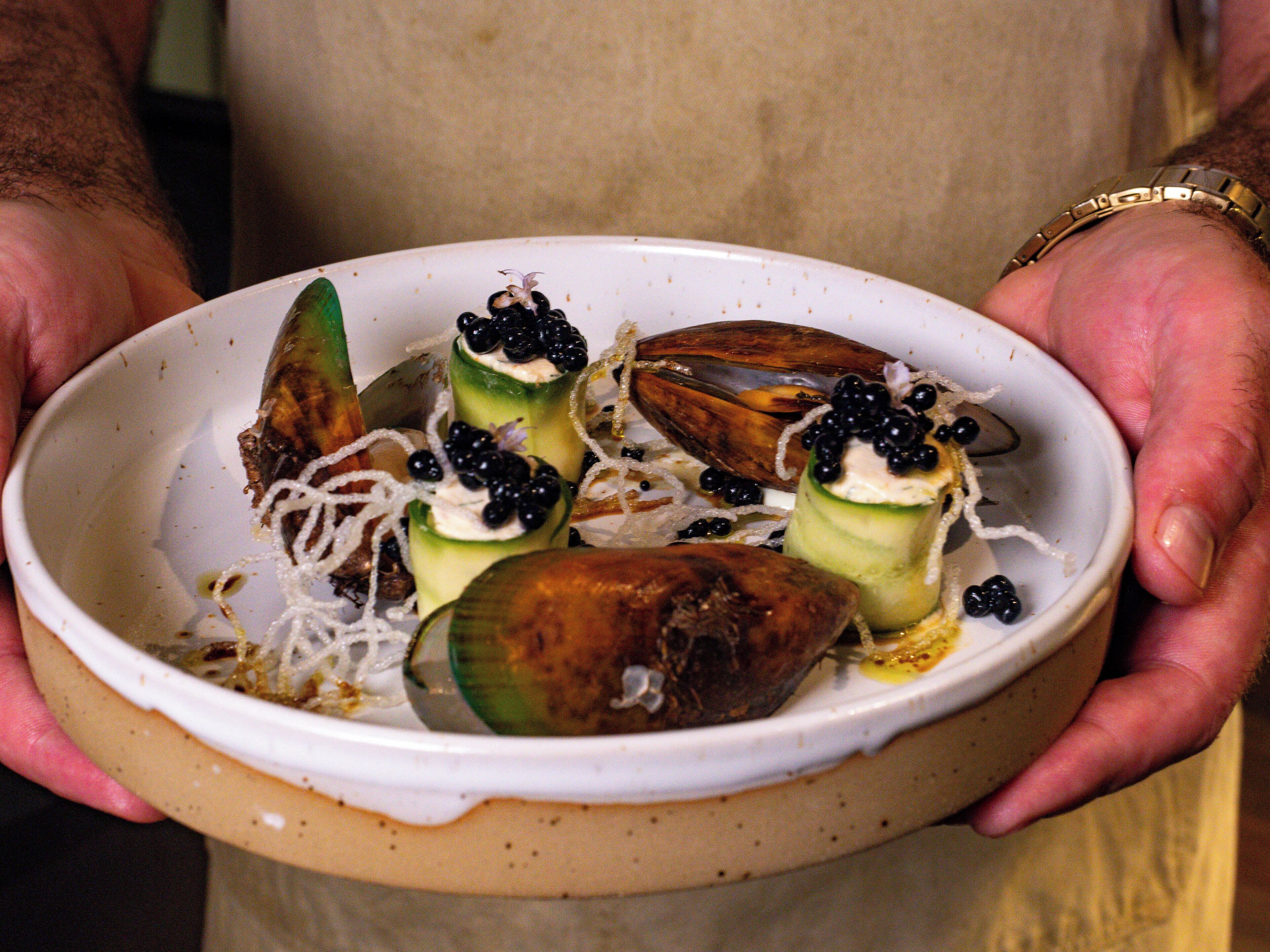 Un plato de comida con mejillones y verduras.