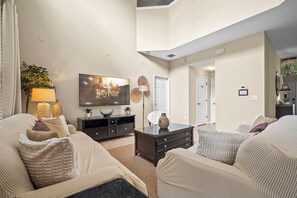 A living room with a flat-screen TV, a sofa, a coffee table, and a decorative lamp. - ⭐ Stunning 6 Bed 5 bath Villa | 4 King Ensuite's | Private Pool | Gated Resort ⭐ (Davenport)
