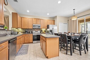 A modern kitchen with wooden cabinets, stainless steel appliances, and a central island with seating. - ⭐ Stunning 6 Bed 5 bath Villa | 4 King Ensuite's | Private Pool | Gated Resort ⭐ (Davenport)