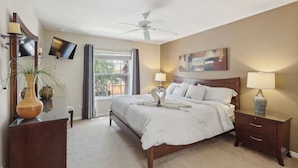 A bedroom with a bed, bedside tables, a TV, a ceiling fan, and a window with curtains. - ⭐ Stunning 6 Bed 5 bath Villa | 4 King Ensuite's | Private Pool | Gated Resort ⭐ (Davenport)