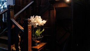Un escalier sur lequel repose un récipient en métal contenant des fleurs blanches.