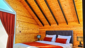 A wooden cabin bedroom with a bed, nightstands, and a window with curtains. - LUNA HOME CLUB (Samandagi)