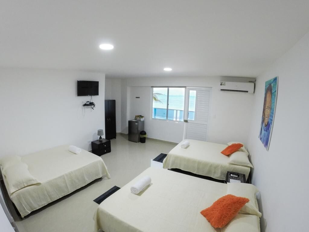 Una camera d'albergo con due letti, televisione, aria condizionata e una finestra vista.