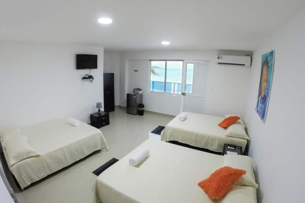 Quarto de hotel com duas camas, televisão, ar-condicionado e janela com vista.