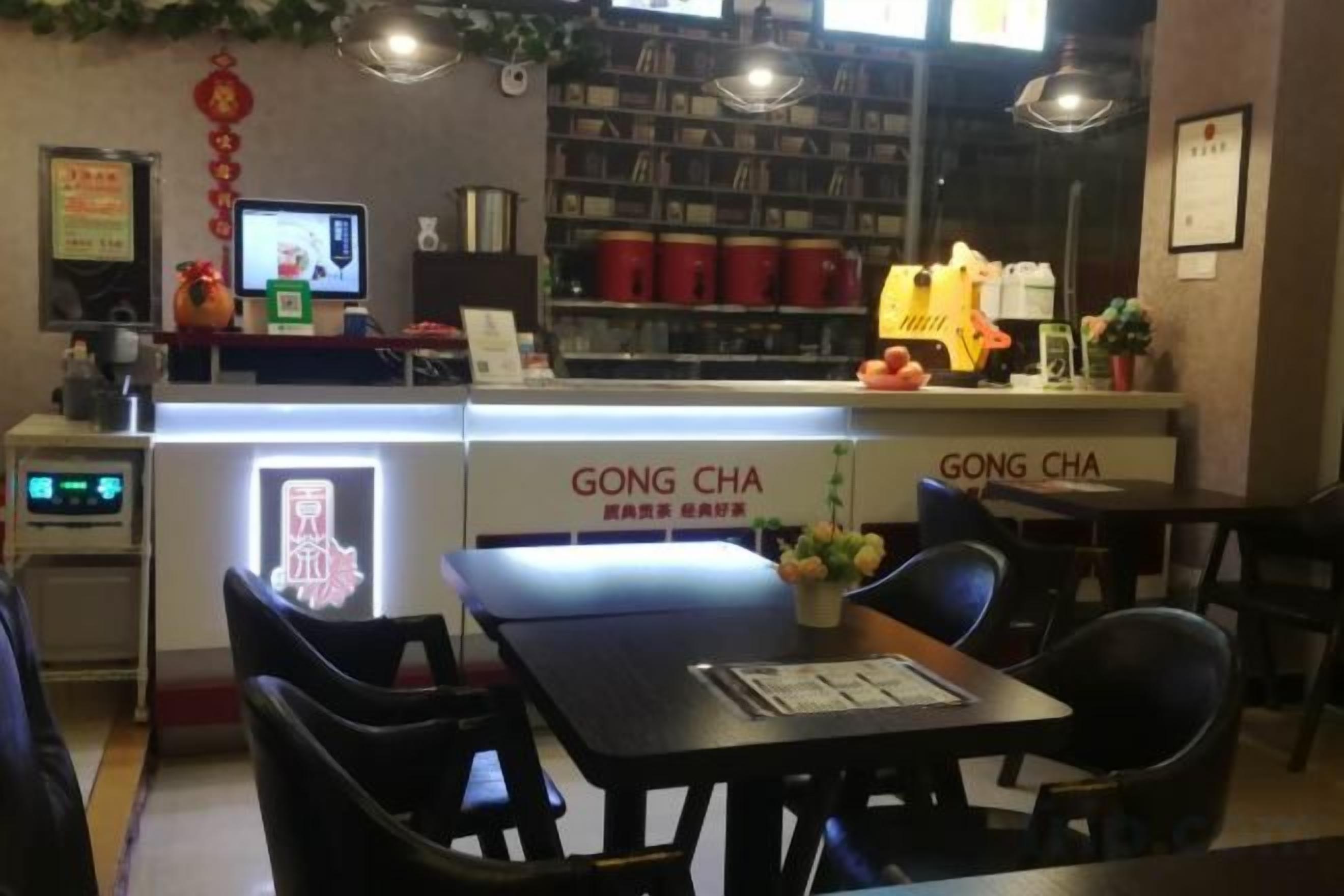 A restaurant interior with a counter, chairs, and a menu display.