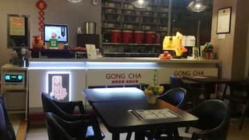 A restaurant interior with a counter, chairs, and a menu display.